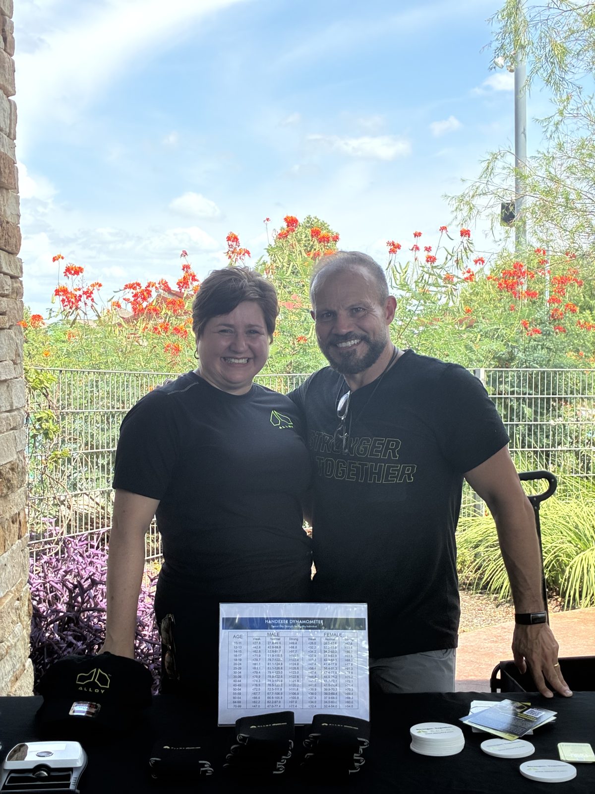 The husband-and-wife owners of Alloy Personal Training, hosts of The Science of Living Well, in Stronger Together shirts